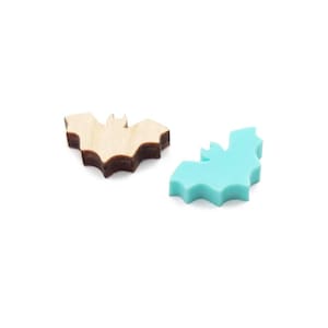 May include: Two bat-shaped decorations, one made of wood with a brown stain and one made of turquoise blue plastic.