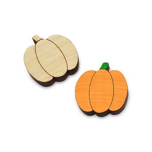 May include: Two wooden pumpkin ornaments, one is natural wood and the other is painted orange.