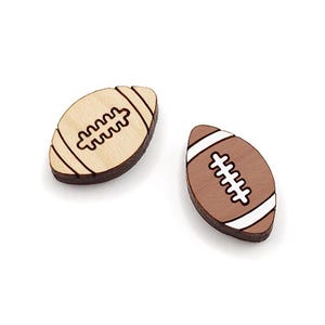 May include: Two wooden football-shaped ornaments, one is natural wood with a brown stitching design, the other is brown with white stitching.