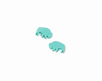 May include: Two turquoise blue buffalo silhouette shaped earrings.