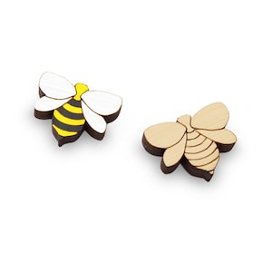 May include: Two wooden bee ornaments, one with black and yellow stripes and white wings, the other with natural wood color and a light brown stripe pattern.