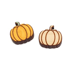 May include: Two wooden pumpkin ornaments, one is yellow and the other is a natural wood color.