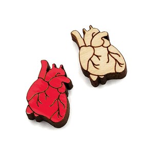 May include: Two wooden heart-shaped ornaments, one painted red and the other left natural wood.