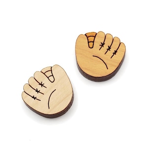May include: Two wooden baseball glove ornaments. The gloves are light brown and have black stitching details.