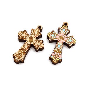 May include: Two wooden cross charms with intricate floral designs. One cross is painted in shades of pink, blue, and yellow, while the other is a natural wood color.