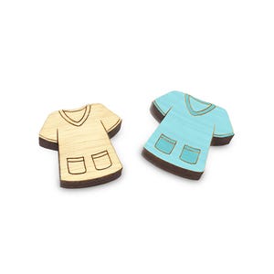 May include: Two wooden scrub tops, one is light brown and the other is light blue. Both have a V-neck and two pockets.