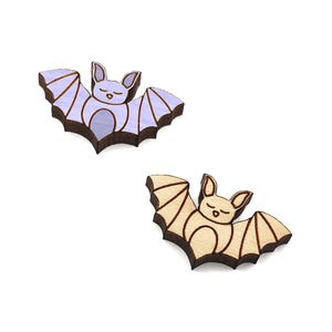 May include: Two wooden bat cutouts, one purple and one natural wood color. Both bats have a simple, cartoon-like face.