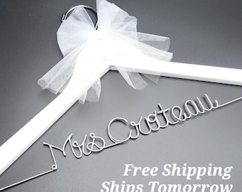 May include: White wooden hanger with a tulle bow and the words "Mrs. Crteall" in silver wire lettering.