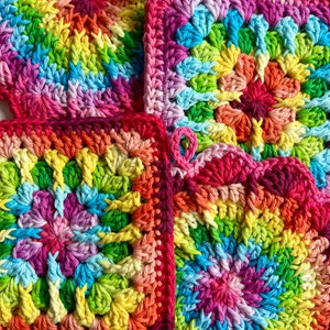 May include: Three colorful crocheted squares with a rainbow swirl pattern. The squares are made with a variety of colors, including pink, red, orange, yellow, green, blue, and purple.