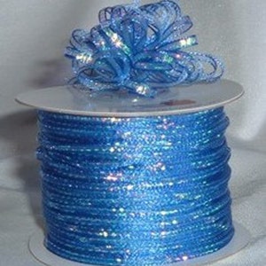 Puede incluir: Una bobina de cinta azul iridiscente con un lazo azul y blanco a juego en la parte superior.