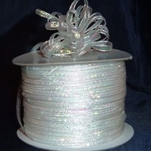 May include: A spool of iridescent white ribbon with a bow made from the same ribbon.
