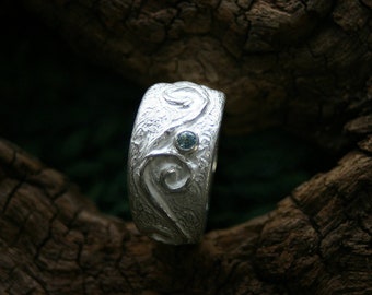 Enchanting ring with spiral ornaments and framed blue topas