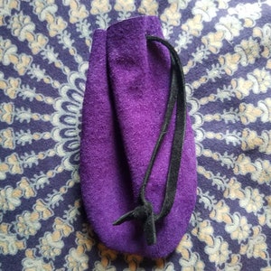 May include: A purple velvet drawstring pouch with a black cord.