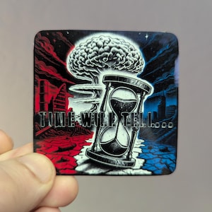May include: Square sticker with a black and white hourglass, a mushroom cloud, and the text "TIME WILL TELL...". The background is split red and blue with city silhouettes.