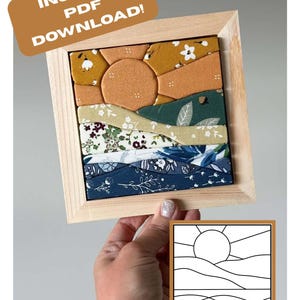 May include: A square wooden frame containing a fabric mosaic of a sun setting over rolling hills and water. The fabric pieces feature floral and solid patterns in mustard yellow, orange, sage green, and navy blue. Includes an instant PDF download label.