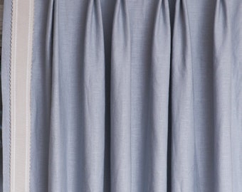 May include: Light blue curtains with a white and light gray trim. The curtains are hung on a metal rod.
