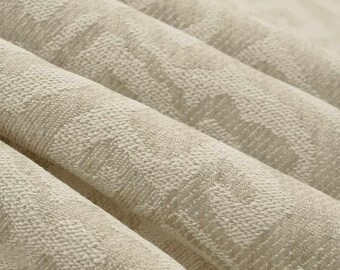 May include: Close-up of a beige fabric with a textured, woven pattern. The fabric has a subtle, light brown color and a slightly rough texture.