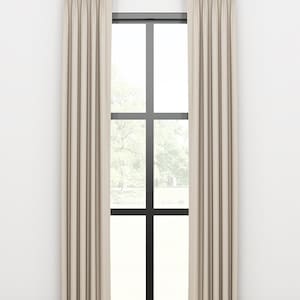 May include: A pair of off-white linen curtains with pleats hanging from a gold curtain rod in front of a window with black trim.