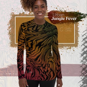 May include: A woman is wearing a long-sleeved shirt with a black, orange, and red abstract pattern. The shirt has a crew neck and long sleeves. The text "Urban Jungle Fever" is visible in the image.