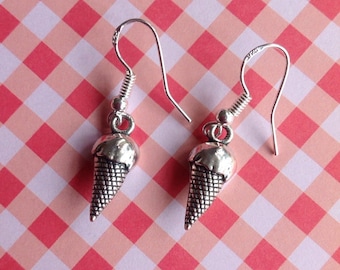 May include: A pair of silver ice cream cone earrings. The earrings are dangle style with a silver hook.
