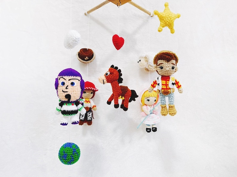 Puede incluir: Un m&oacute;vil de crochet con personajes de la franquicia Toy Story. El m&oacute;vil incluye a Woody, Buzz Lightyear, Jessie, Bullseye y una estrella. El m&oacute;vil est&aacute; hecho con hilo de colores y es perfecto para la habitaci&oacute;n de un beb&eacute;.