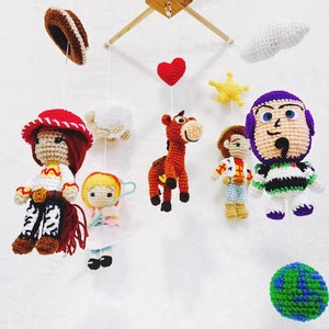 Puede incluir: Un m&oacute;vil de crochet con personajes de la pel&iacute;cula Toy Story. El m&oacute;vil incluye a Woody, Jessie, Buzz Lightyear, Bullseye, una nube, una estrella, un coraz&oacute;n y un globo terr&aacute;queo.