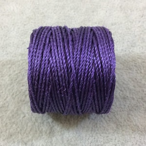 May include: A spool of purple embroidery floss.