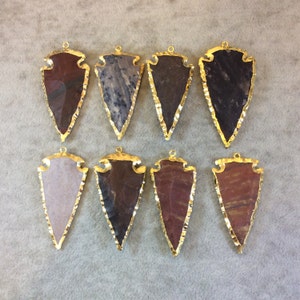 May include: Eight arrowhead shaped pendants with gold trim. The arrowheads are made of various types of agate and are ready to be used in jewelry making.