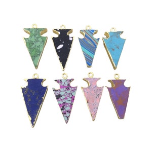 May include: Eight gold-rimmed arrowhead pendants with different colored agate stones. The stones are in shades of blue, green, pink, purple, and black.