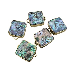 May include: Four square-shaped charms featuring iridescent abalone shell inlays set within gold-toned metal frames. Each charm displays unique swirling patterns of blue, green, and purple hues, with small circular loops attached to the sides.
