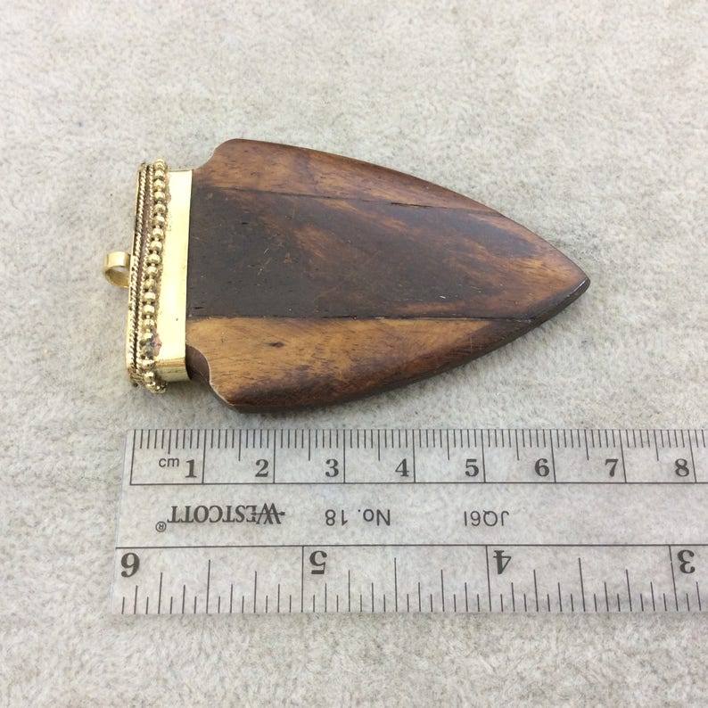 Measuring 45mm x 70mm TR275WBNFA Approximately - 2.75 Warm Brown Notched Arrow Shaped Natural Ox Bone Pendant with Dotted Gold Cap