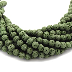 May include: A strand of dark green lava rock beads. The beads are round and have a porous texture.