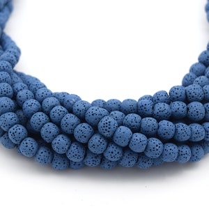 May include: A strand of blue lava rock beads. The beads are round and have a rough, porous texture.