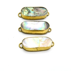May include: Three oval-shaped brass connectors with iridescent abalone shell inlays. The connectors have two loops on either side for attaching to jewelry or other crafts.