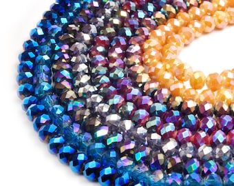 Peut inclure: Gros plan sur une collection de perles à facettes de différentes couleurs. Les perles passent du bleu profond aux violets irisés, aux gris et enfin aux oranges chauds. Les perles sont enfilées, suggérant leur utilisation dans la fabrication de bijoux ou l'artisanat.