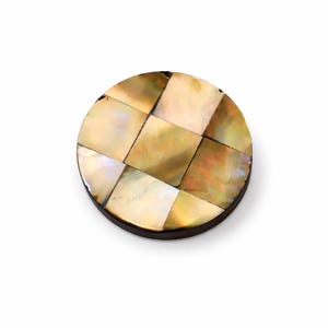 Puede incluir: Un posavasos redondo y decorativo con un diseño de tablero de ajedrez. Está hecho de piezas cuadradas e iridiscentes de nácar en tonos dorados, crema y marrón. El posavasos tiene un borde de madera marrón oscuro. Mide unos 10 cm de diámetro.