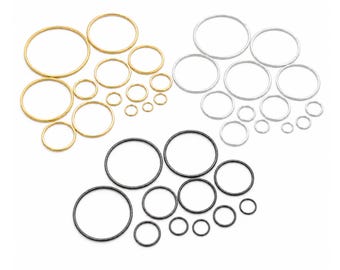Puede incluir: Una colección de anillos metálicos circulares dispuestos en tres grupos de colores distintos: oro, plata y negro. Cada grupo contiene múltiples anillos de diámetros variados, desde grandes a pequeños, todos con una estructura fina y lisa.