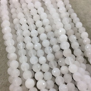 May include: A strand of white jade beads. The beads are round and have a smooth, polished finish.