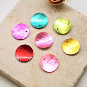 Puede incluir: Surtido de siete lentejuelas redondas iridiscentes con forma de concha con un agujero en el centro. Las lentejuelas son de varios colores, incluyendo rosa, rojo, amarillo, verde y azul.