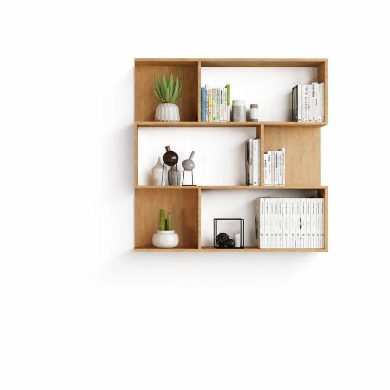 Modern wooden wall-mounted bookshelf with open compartments, shown isolated on a clean white background.
