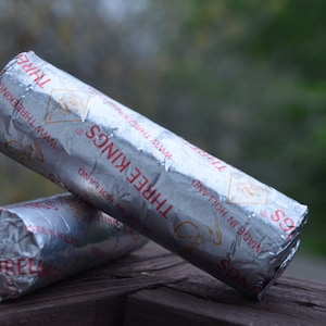 May include: Two silver charcoal briquettes for shisha, labeled "Three Kings" and "Made in Holland".
