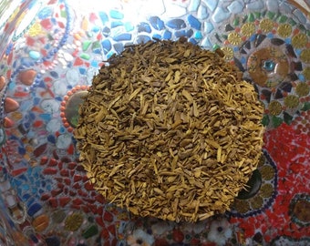 May include: A close-up of a bowl filled with dried, brown, shredded bark. The bark is in a pile in the center of the bowl. The bowl is on a colorful, mosaic surface.