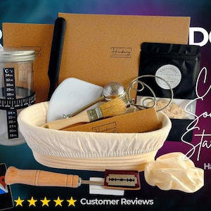 May include: A white ceramic mug with a black handle and the text "But First, Coffee" in a bold, black font. The mug is set against a blurred background, suggesting a cosy setting.