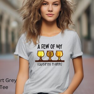 Könnte beinhalten: Hellgraues T-Shirt mit dem Text "A FEW OF MY favorite things" und drei Biergläsern. Das Shirt ist ein Sport Grey Tee.