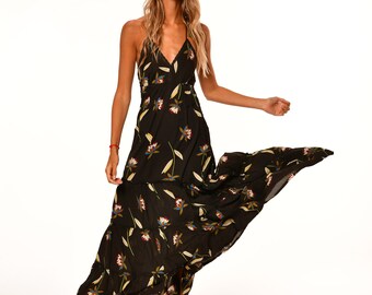 May include: A black maxi dress with a floral print. The dress has a halter neckline and a tiered skirt.