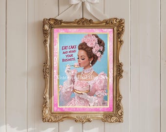 Può includere: Una stampa incorniciata con un'illustrazione vintage di una donna in abito rosa che mangia una torta. La stampa ha una cornice dorata ornata e un fiocco bianco in alto. Il testo sulla stampa recita "EAT CAKE AND MIND YOUR BUSINESS."