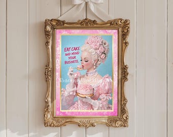 Può includere: Una stampa incorniciata con una cornice dorata ornata, raffigurante una donna in abito rosa e acconciatura elaborata, che mangia una torta. La stampa ha il testo "EAT CAKE AND MIND YOUR BUSINESS." e un fiocco bianco in alto.
