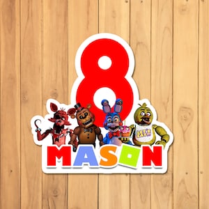 May include: A red number eight with a white outline, surrounded by five characters from the video game Five Nights at Freddy's. The characters are Freddy Fazbear, Bonnie the Bunny, Chica the Chicken, Foxy the Pirate Fox, and a cupcake. The text "MASON" is below the characters in colorful letters.