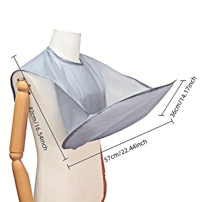 Op de afbeelding: Grijze haar knip cape met een brede, afgeronde halslijn. De cape is 57 cm / 22,44 inch breed en 42 cm / 16,54 inch lang. De cape is 36 cm / 14,17 inch hoog.
