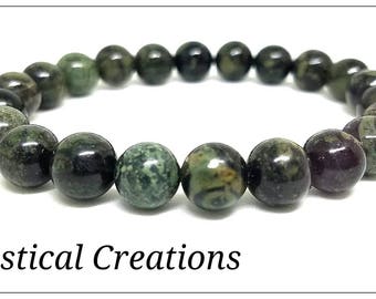 May include: A green and black gemstone bracelet with a variety of patterns. The bracelet is made of round beads and is approximately 8 inches in length.